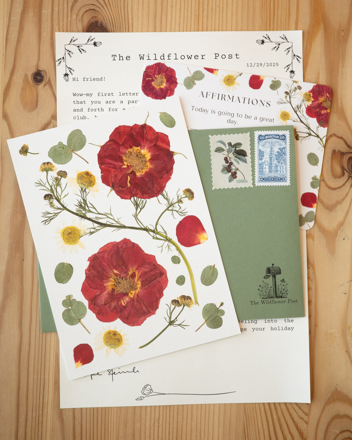 Print of pressed rose with letter and affirmation card on table. 