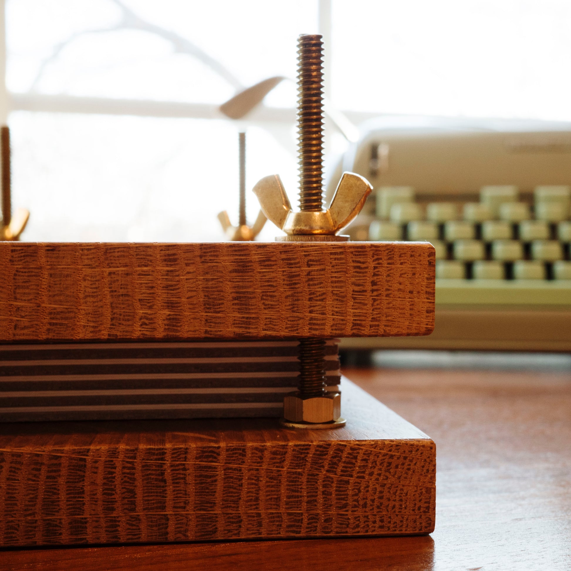 Close up of wood flower press with brass bolts.