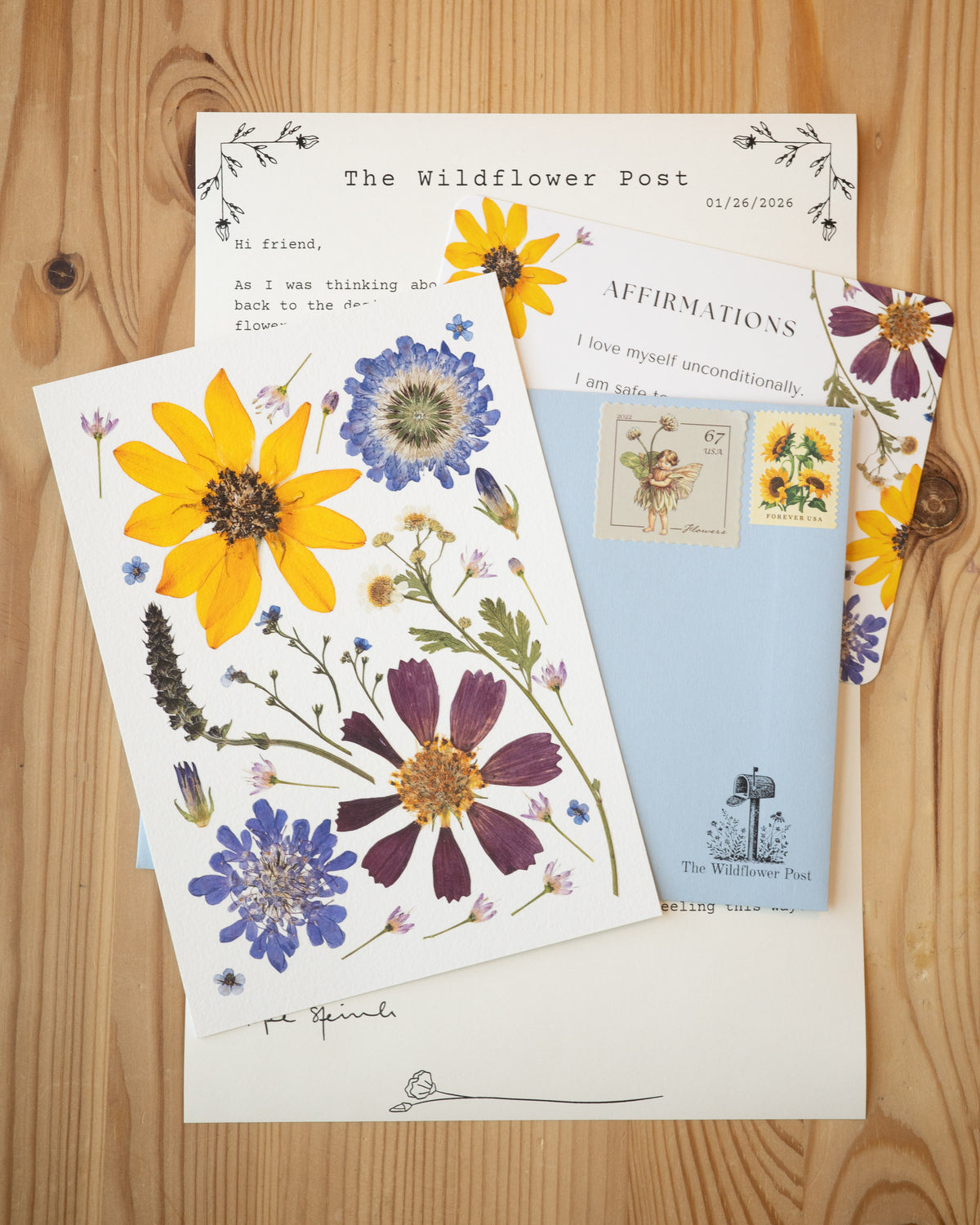 Art print of pressed cosmos, pincushion, and other flowers with letter and affirmation card.