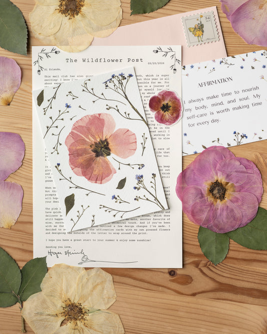 pressed flowers surrounding a letter and pressed flower art print with an affirmation card