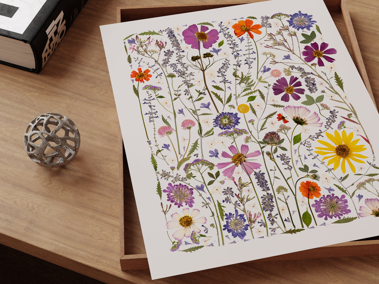 Art print of pressed wildflowers with colorful blossoms on a desk.