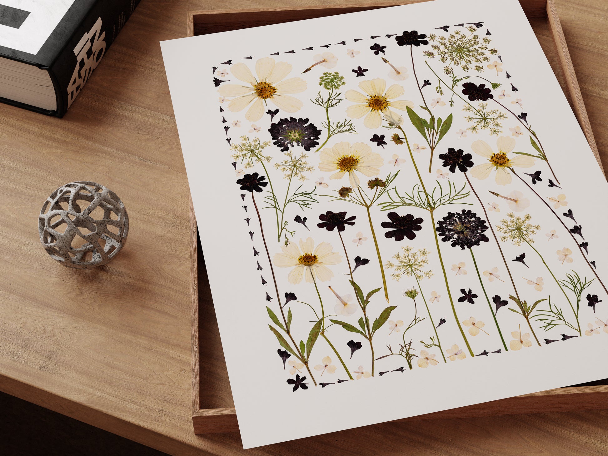 Pressed flower art print collage sitting on a desk.