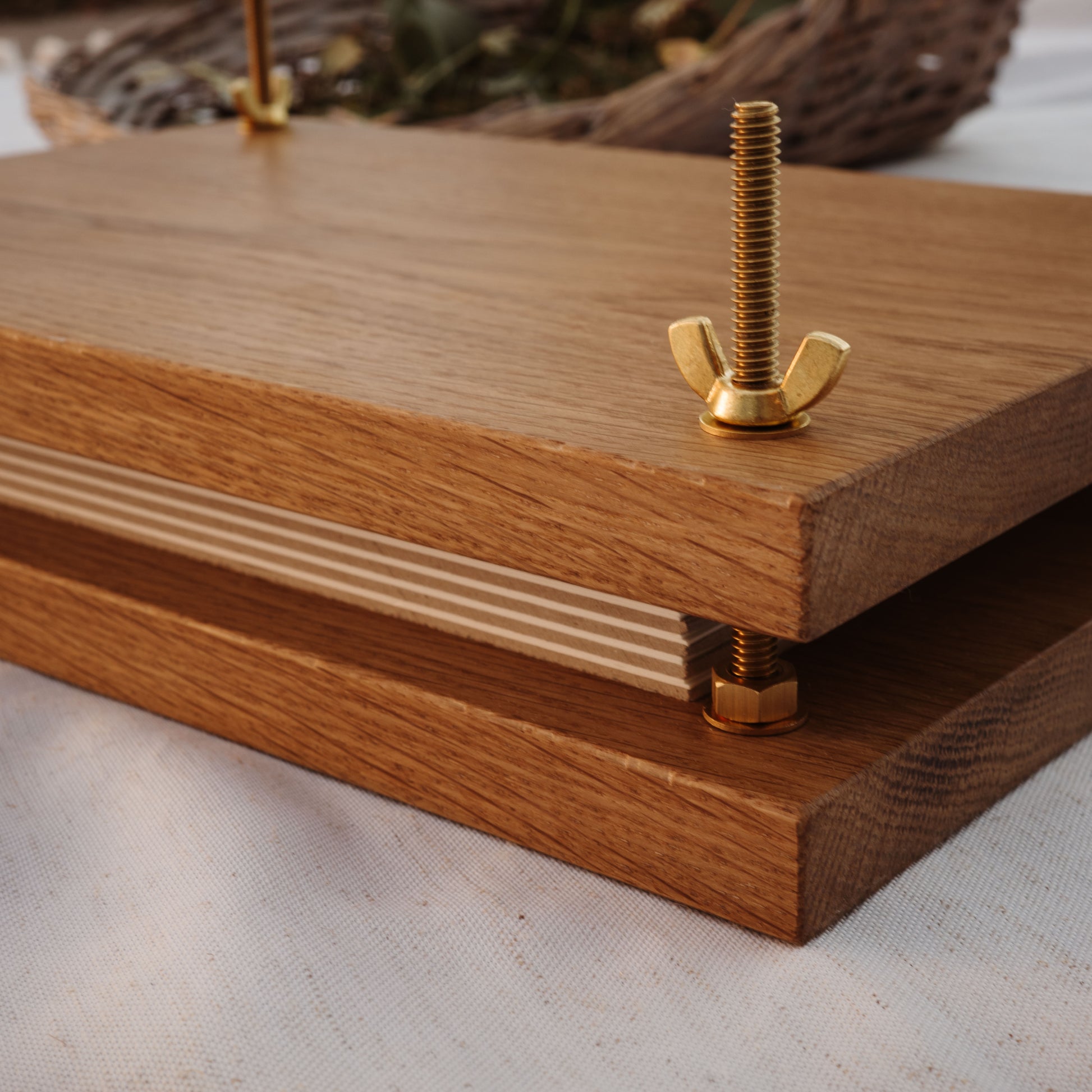 Close up of wood plant press with brass bolts and blotting paper and chipboard.